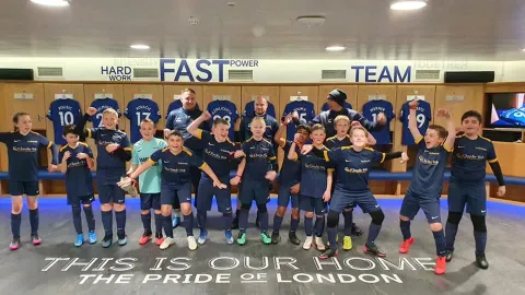 Youth team gathered together in their stadium changing room.