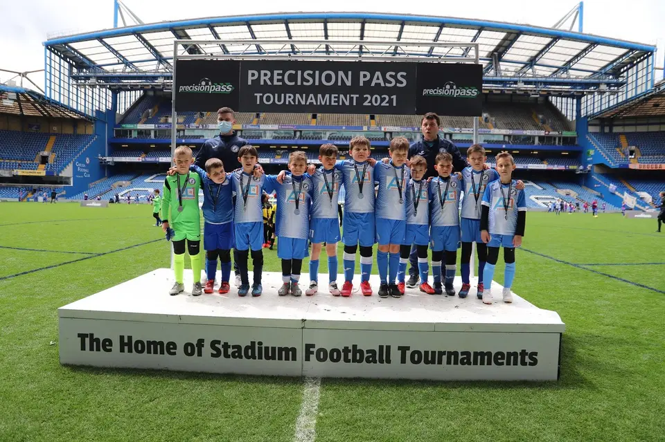 Young players celebrating together after a stadium tournament.